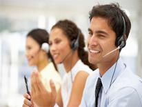 Customer Contact Center Man and two women on the phone in a call center